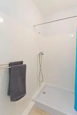 a white bathroom with a towel hanging on a wall at Ribeira Vintage Suite in Porto