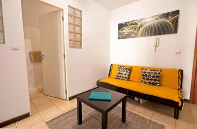 a living room with a yellow couch and a table at Ribeira Vintage Suite in Porto