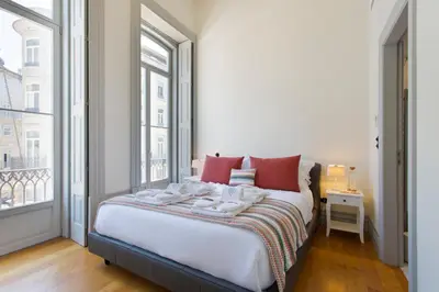 a bedroom with a bed with red pillows and a window at BOUTIQUE Rentals - Toledos One & Only Apt in Historical center of Porto in Porto
