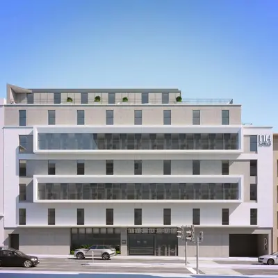 a large white building with cars parked in a parking lot at NH Porto Jardim in Porto