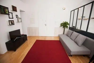 a living room with a couch and a red rug at GET Lights and Books in Flat in Porto