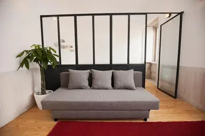 a couch in a room with a potted plant at GET Lights and Books in Flat in Porto
