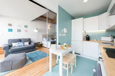 a kitchen and living room with a table and a couch at Fontaínhas Stylish Apartment by DA'HOME in Porto