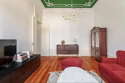 a living room with a red couch and a tv at O da Joana in Porto