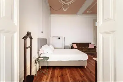 a white bedroom with a bed and a table at O da Joana in Porto