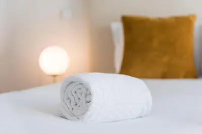 a roll of white towels sitting on a bed at Backyard Palace Terrace in Porto
