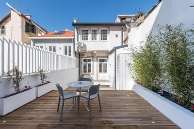 a small balcony with a table and chairs on a wooden floor at Backyard Palace Terrace in Porto