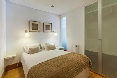 a white bedroom with a bed and a glass door at Go2oporto - Ribeira do Porto in Porto