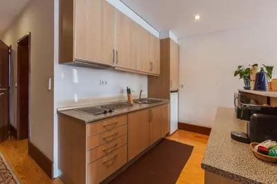 a kitchen with wooden cabinets and a counter top at Go2oporto - Ribeira do Porto in Porto