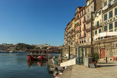 a group of buildings next to a river with boats at Go2oporto - Ribeira do Porto in Porto