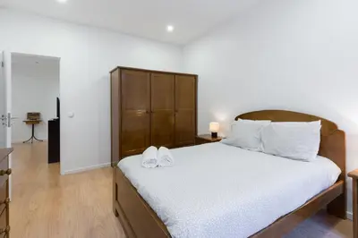 a bedroom with a bed with two white shoes on it at Porto Belomonte Flats in Porto