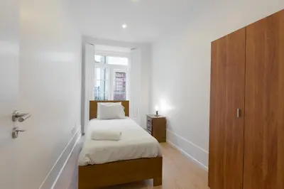 a small bedroom with a bed and a window at Porto Belomonte Flats in Porto