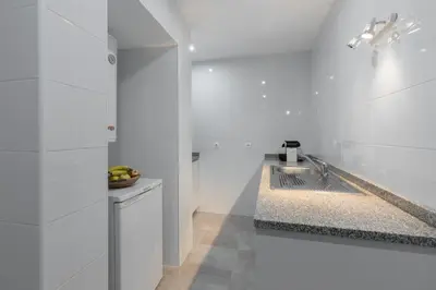 a white kitchen with a sink and a counter at Porto Belomonte Flats in Porto