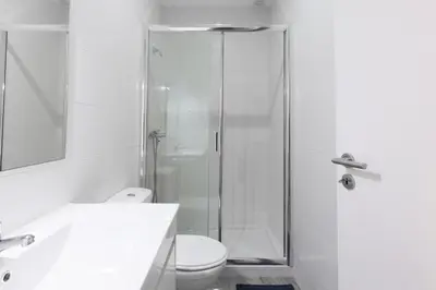 a bathroom with a shower and a toilet and a sink at Porto Belomonte Flats in Porto