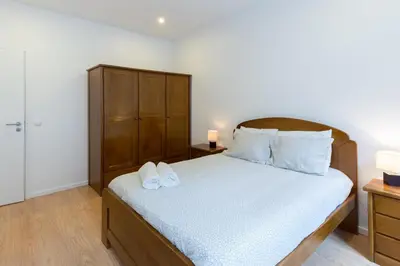 a bedroom with a bed with a wooden headboard at Porto Belomonte Flats in Porto
