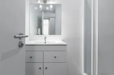 a white bathroom with a sink and a mirror at Porto Belomonte Flats - T2 in Porto