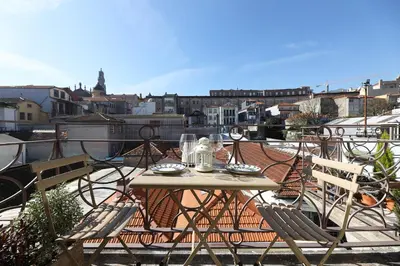 a table and chairs on top of a balcony at FLH Almada Cozy Apartment with View in Porto