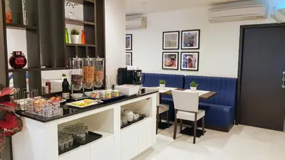 a restaurant with a counter and a table and chairs at Porto City Hotel in Porto