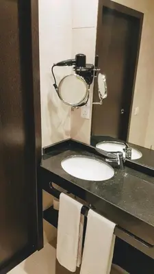 a bathroom with two sinks and a mirror at Porto City Hotel in Porto