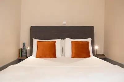 a bedroom with a bed with two orange pillows at RIBEIRA CHARMING APARTMENTS in Porto