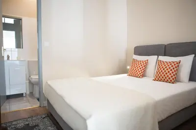 a bedroom with a bed with orange and white pillows at RIBEIRA CHARMING APARTMENTS in Porto