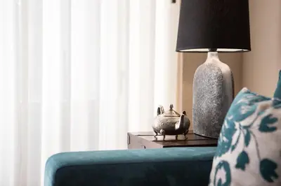 a lamp sitting on a table next to a blue couch at RIBEIRA CHARMING APARTMENTS in Porto