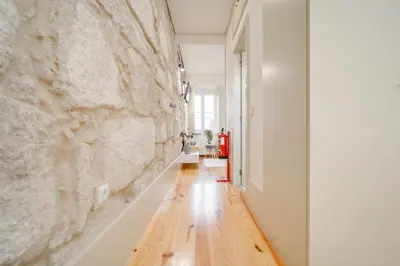 a hallway with a stone wall and a wooden floor at Nomad's Bonjardim City Flats in Porto