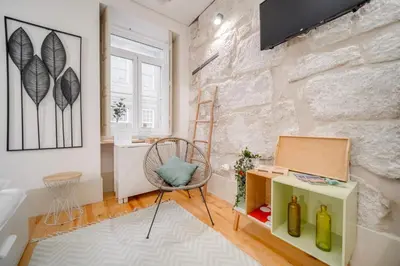 a room with a chair and a stone wall at Nomad's Bonjardim City Flats in Porto