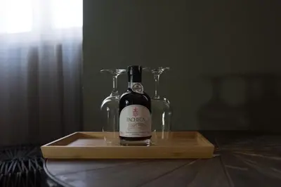 a bottle of wine and two glasses on a wooden tray at Olive Nature – Tourism Apartments in Porto