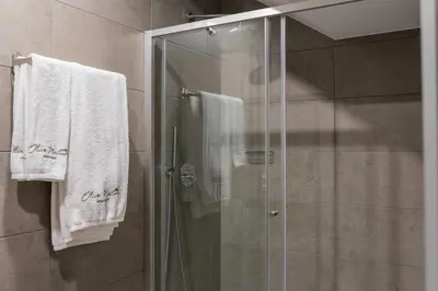 a shower with white towels in a bathroom at Olive Nature – Tourism Apartments in Porto
