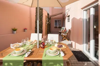 a dining table with a green table cloth and an umbrella at Alves da Veiga Apartments in Porto