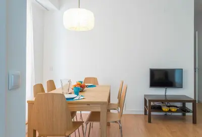 a dining room with a table with chairs and a television at Alves da Veiga Apartments in Porto