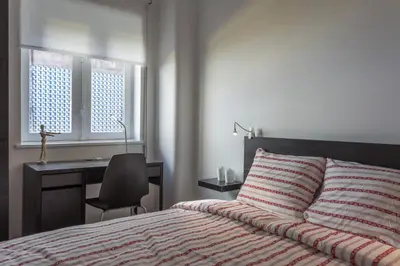 a bedroom with a bed with a desk and a chair at Alves da Veiga Apartments in Porto