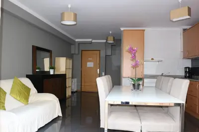 a living room with a table and two white chairs at Studios Porto Solar in Porto