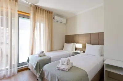 two beds in a hotel room with towels on them at Studios Porto Solar in Porto