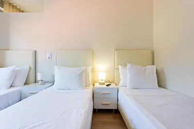 two beds in a room with white sheets and pillows at Studios Porto Solar in Porto
