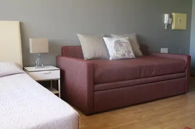 a red couch sitting in a room with a bed at Studios Porto Solar in Porto