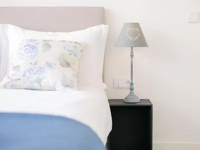 a bed with a pillow and a lamp on a night stand at CM VINTAGE Apartments - Breiner in Porto