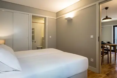 a bedroom with a white bed and a table at Porto Republica Apartments in Porto