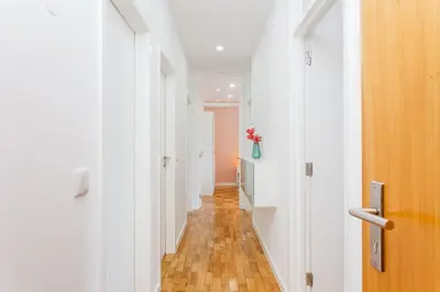 a hallway with white walls and a wooden floor at Sancha Apartment - in the Centre near the Aliados in Porto