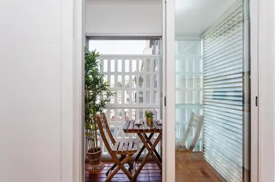 an open door to a balcony with a table and chairs at Sancha Apartment - in the Centre near the Aliados in Porto