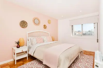 a white bedroom with a bed and a window at Sancha Apartment - in the Centre near the Aliados in Porto