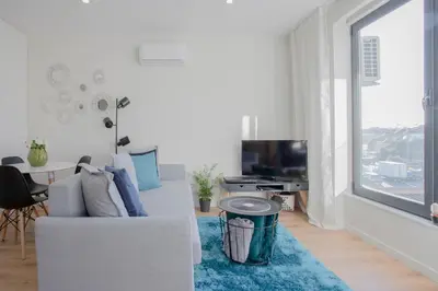 a living room with a white couch and a large window at Liiiving in Porto I Bright Light Studio in Porto