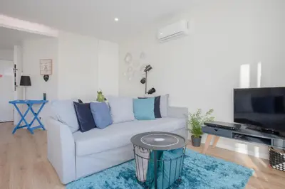 a living room with a white couch and a tv at Liiiving in Porto I Bright Light Studio in Porto