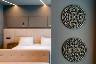 a bedroom with a bed and a wall with a mirror at Rubens Hotels & SPA in Vila Nova de Gaia