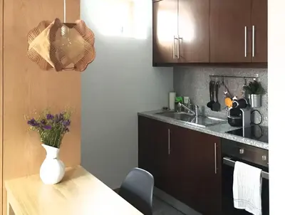 a kitchen with a table with a vase of flowers on it at Casa do Bairro 2 in Porto