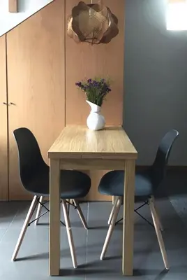 a wooden table with two chairs and a vase on it at Casa do Bairro 2 in Porto
