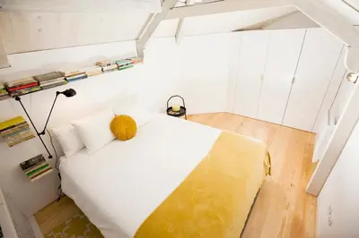 a bedroom with a white bed with a yellow blanket at GET a Cactus and Books studio in Porto