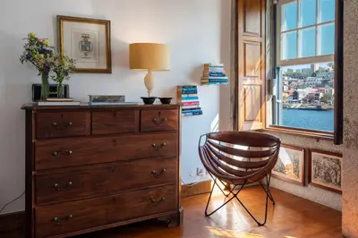 a dresser and a lamp in a room with a window at Porto Premium River View I in Porto