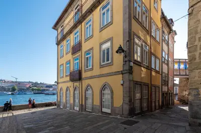 a yellow building next to a body of water at Porto Premium River View I in Porto